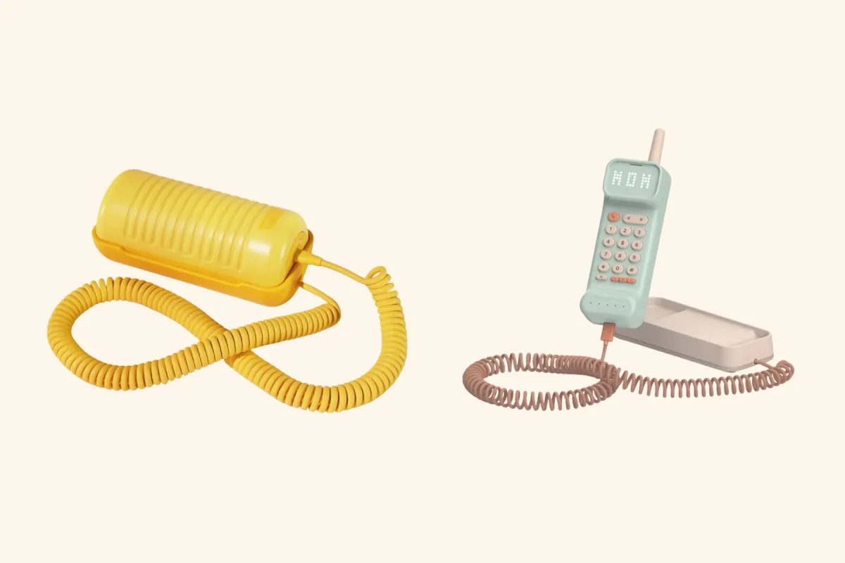 A yellow Tin Can landline next to a mint Waffle Home handset on its base, both on coiled cords